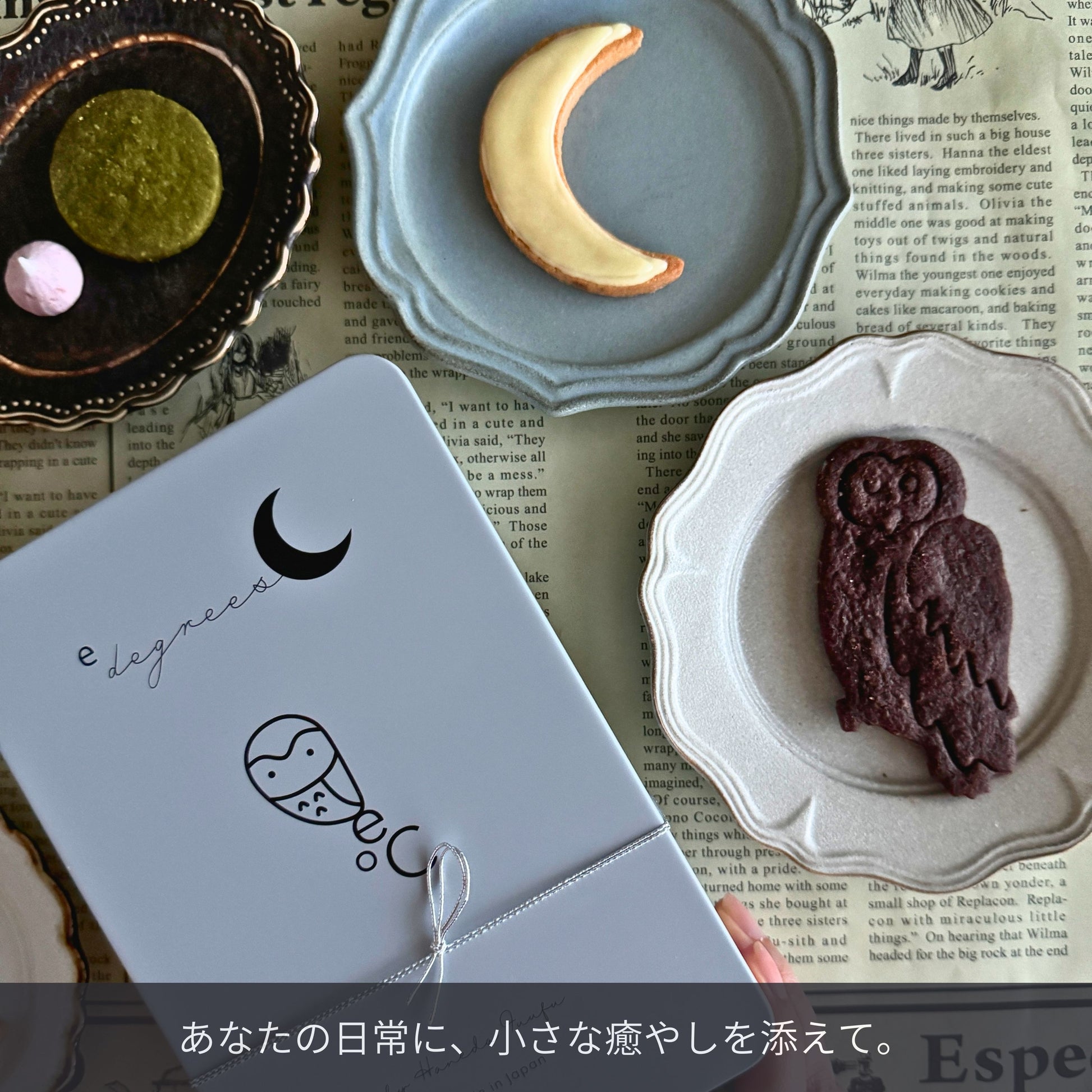 福を呼ぶフクロウとお月さまのクッキー缶。三日月や抹茶クッキーが並ぶかわいいお皿と、ギフトに人気のお取り寄せスイーツのパッケージ。